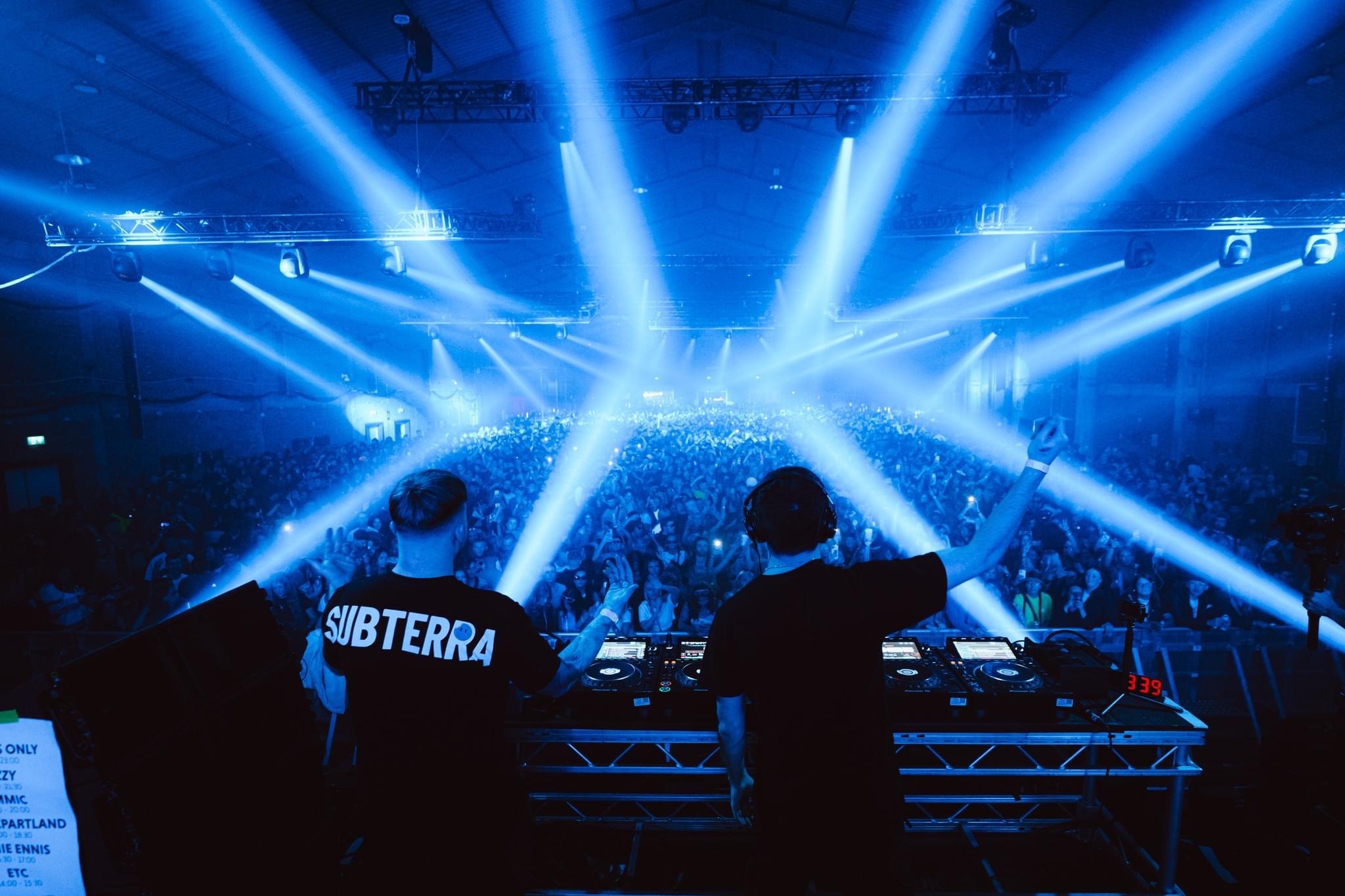KIMMIC behind the decks under blue stage lights