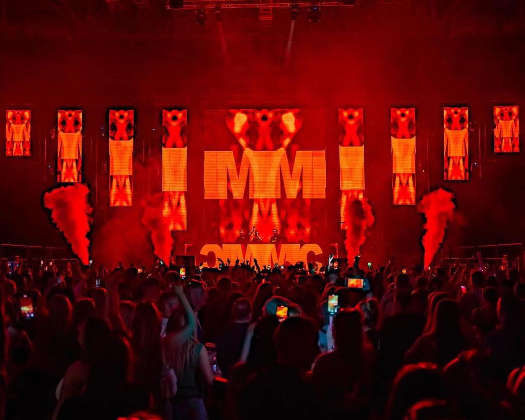 KIMMIC performing on a red-lit stage